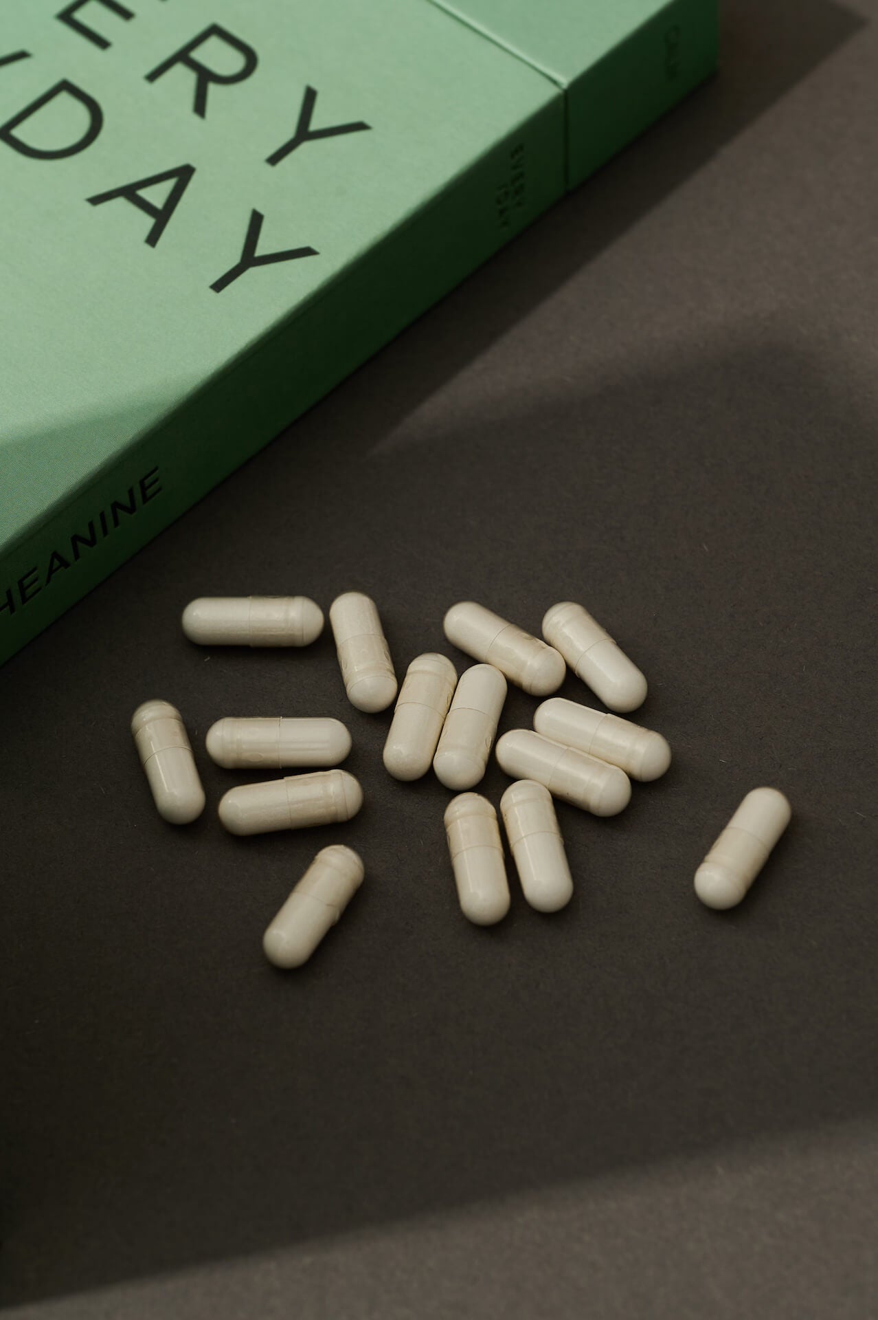 Close-up of 200mg L-Theanine capsules displayed on a black background, premium food supplement in vegan capsule form